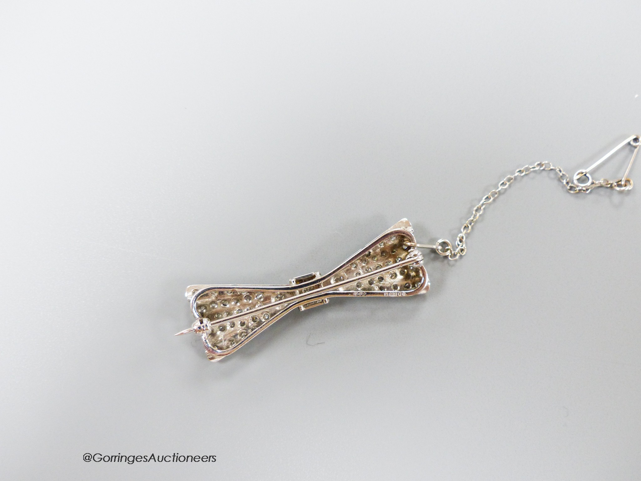 A modern Art Deco style 18ct white gold and diamond encrusted 'bow tie' brooch, 40mm, gross 7.1 grams.